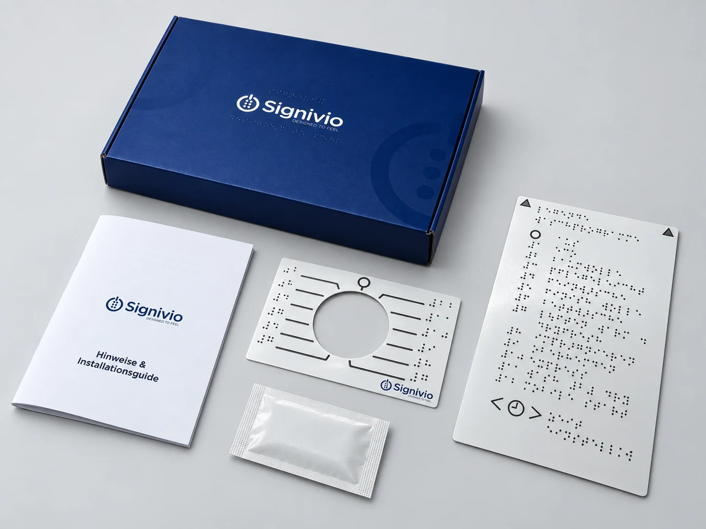 Visualisation of the contents: blue Signivio box, tactile label, Braille reference plate, instructions and a packaged alcohol wipe.