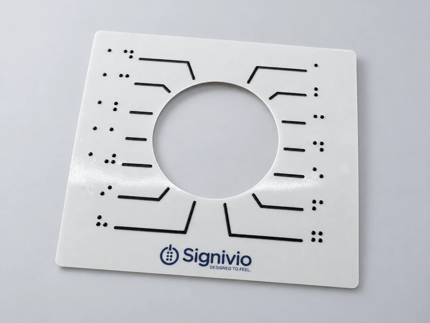 Product visualisation of a Signivio label: a circular opening for the dial, raised guide lines and Braille numbers.